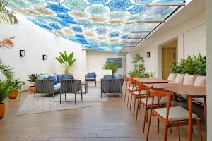 an office with a cafeteria with tables and chairs at District Polanco by Lumina in Mexico City