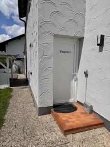 a white door with the word on the side of a building at IV Apartment 12 Personen - Monteurzimmer - Ferienwohnung - Kronwieden in Loiching