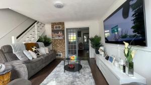 a living room with a couch and a tv at Single Room Near Basildon City Centre in Basildon