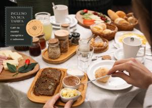 Una mesa llena de comida con una persona comiendo. en Pousada Astral da Ilha, en Ilha do Mel