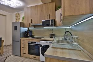 a kitchen with a dishwasher sink and a refrigerator at Karolina Apartman in the silent 11th district in Budapest