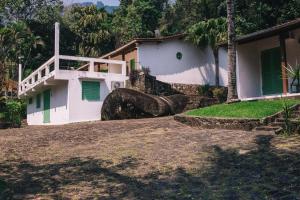 a house with a large rock in front of it at Ilhabela Chalés in Ilhabela