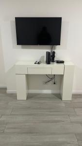 un bureau blanc avec une télévision à écran plat sur un mur dans l'établissement Entre rios 2, à Rosario
