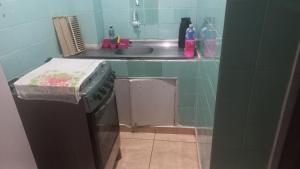 a small kitchen with a sink and a stove at Kit no centro de Mongagua em frente o mar in Mongaguá +14 photos