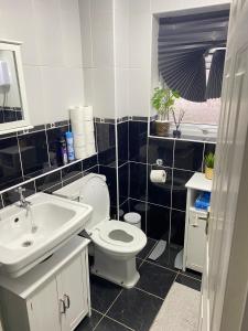 a bathroom with a white toilet and a sink at Single Room Near Basildon City Centre in Basildon +4 photos