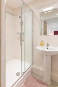 Un baño blanco con lavabo y ducha. en The Lincoln Apartment 2023 NEW-BUILD, 1 mintue walk JR John Radcliffe Hospital & Ideal for Oxford Brookes University, en Oxford