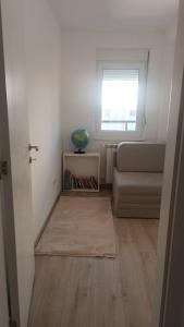 a living room with a couch and a window at Central City Stay - Apartment Alex in Šabac