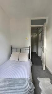 a bedroom with a large bed with white sheets at Single Room Near Basildon City Centre in Basildon