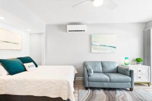 a bedroom with a bed and a blue chair at Beach Rd, 300ft to Beach Access & 500ft to Siesta Key Village, Studio in Siesta Key