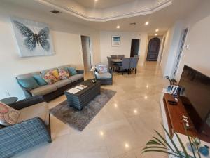 a living room with a couch and a dining room at 403 Landmark Resort Cozumel beachfront condo in Cozumel