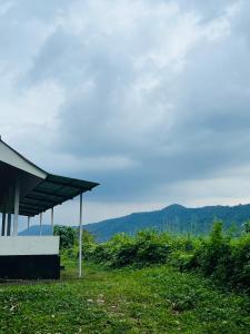 a building with a roof with mountains in the background at 7FORT HOMESTAY Athirappilly in Athirappilly +8 photos