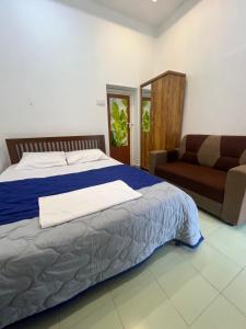 a bedroom with a bed and a couch at 7FORT HOMESTAY Athirappilly in Athirappilly