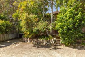 a house with trees and stairs in front of it at Just Beachy in Boomerang Beach