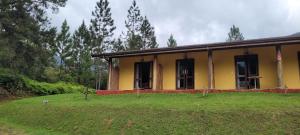 a yellow house with a yard in front of it at Pousada Ananda Parivara in Ubatuba