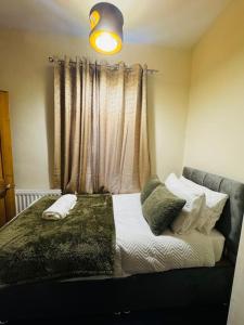 Un dormitorio con una cama con almohadas y una ventana. en Cosy 2 bedroom house in Leicester- entire house, sleeps 5, en Leicester