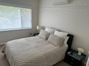 a bedroom with a large bed with a window at The Granth - your perfect river escape in Cobram