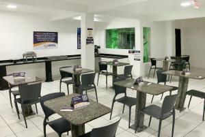 Un restaurante con mesas y sillas en una sala. en OK Inn Hotel Criciúma, en Criciúma 19 fotos más