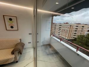 einen Balkon mit einem Sofa und Stadtblick in der Unterkunft Boabdil Luxury home in Córdoba