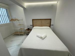 ein weißes Bett mit gefaltetem Handtuch darauf in der Unterkunft Boabdil Luxury home in Córdoba