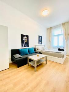 ein Wohnzimmer mit einer Couch und einem Tisch in der Unterkunft 5BR Shared Apt Ideal for Groups 7 Min to Westbahnhof in Wien
