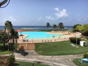 a large swimming pool with the ocean in the background at Grand studio les pieds dans l'eau! in Saint-François