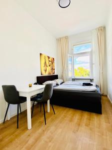 ein Schlafzimmer mit einem Bett, einem Schreibtisch und einem Fenster in der Unterkunft 5BR Shared Apt Ideal for Groups 7 Min to Westbahnhof in Wien