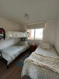 Giường trong phòng chung tại Departamento Papudo a pasos de la Playa