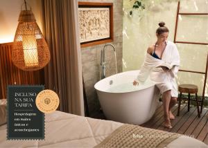 una mujer sentada en una bañera en una habitación en Pousada Astral da Ilha, en Ilha do Mel