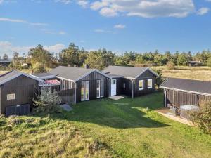 a row of black houses in a field at 8 person holiday home in Hurup Thy-By Traum in Sindrup