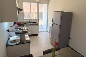 a kitchen with a refrigerator and a counter top at Apartamento cómodo y completo cala cala in Cochabamba
