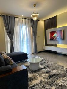Una sala de estar con un sofá y un televisor. en Luxury Budgethomes Bukoto, en Kampala