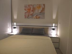 a bedroom with a bed with a painting above it at Madinaty Cozy studio at Privado in New cairo