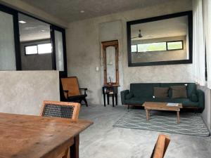 a living room with a green couch and a table at La Flor Casa Boutique in Valladolid