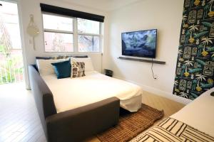 マイアミビーチにあるSouth Beach Studio Free Parking Walk to Ocean Driveのベッドと壁掛けテレビのある寝室