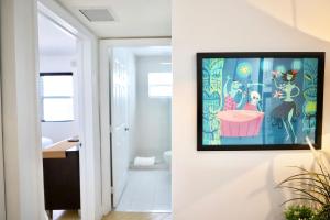 a bathroom with a painting on the wall at South Beach Walk to Sea Free Parking & Balcony Family & Pet Friendly in Miami Beach +32 photos