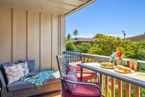 a balcony with chairs and a table with food on it at Nihi Kai 510 in Kipu
