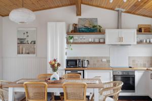 a kitchen with a wooden table and chairs at Bush Hideaway by the beach in Binalong Bay