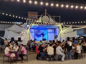 ハジャイにあるGarmin House 8PAX 3BR in Hatyai Townの舞台前の席に座る人々