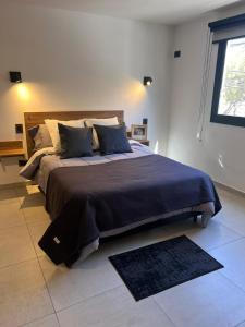 a bedroom with a large bed with a blue blanket at JC Apart in Cordoba