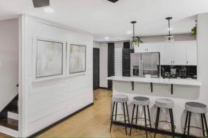 a kitchen with a counter and stools in a room at Chic Memphis 4BR Home with EV Connection in Memphis
