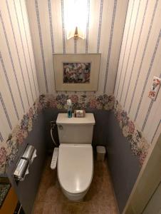a small bathroom with a toilet with flowers on the walls at Hotel IRIS -アイリス- in Osaka