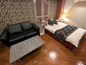 a hotel room with a bed and a couch at Hotel IRIS -アイリス- in Osaka +4 photos