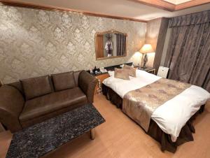 a hotel room with a bed and a couch at Hotel IRIS -アイリス- in Osaka