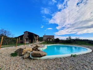 a small swimming pool in front of a house at Masia La Clariana in Castelltallat