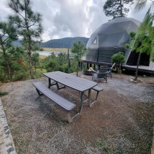 une table de pique-nique avec un banc à côté d'un camping-car dans l'établissement Lobo Glamp Corral De Pierda, à Amanalco de Becerra 10 autres photos