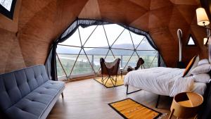 une chambre avec un lit, un canapé et une fenêtre dans l'établissement Lobo Glamp Corral De Pierda, à Amanalco de Becerra