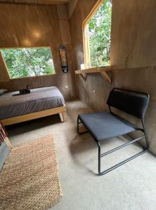 a bedroom with a bed and a chair in it at EB5 Escape-Contemporary Stay, San Marcos La Laguna, Skateboard in San Marcos La Laguna