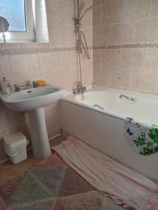a bathroom with a sink and a bath tub and a sink at Wallington Homes in Carshalton