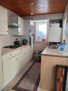 a kitchen with white cabinets and a counter top at Wallington Homes in Carshalton