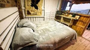 a bedroom with a bed and a desk and a television at Glamping colina campestre ecológica in Duitama